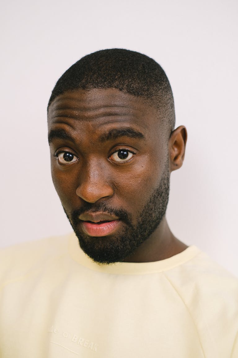 Berniece Julien Close-up portrait of a man with a neutral white background, showcasing expression and style.