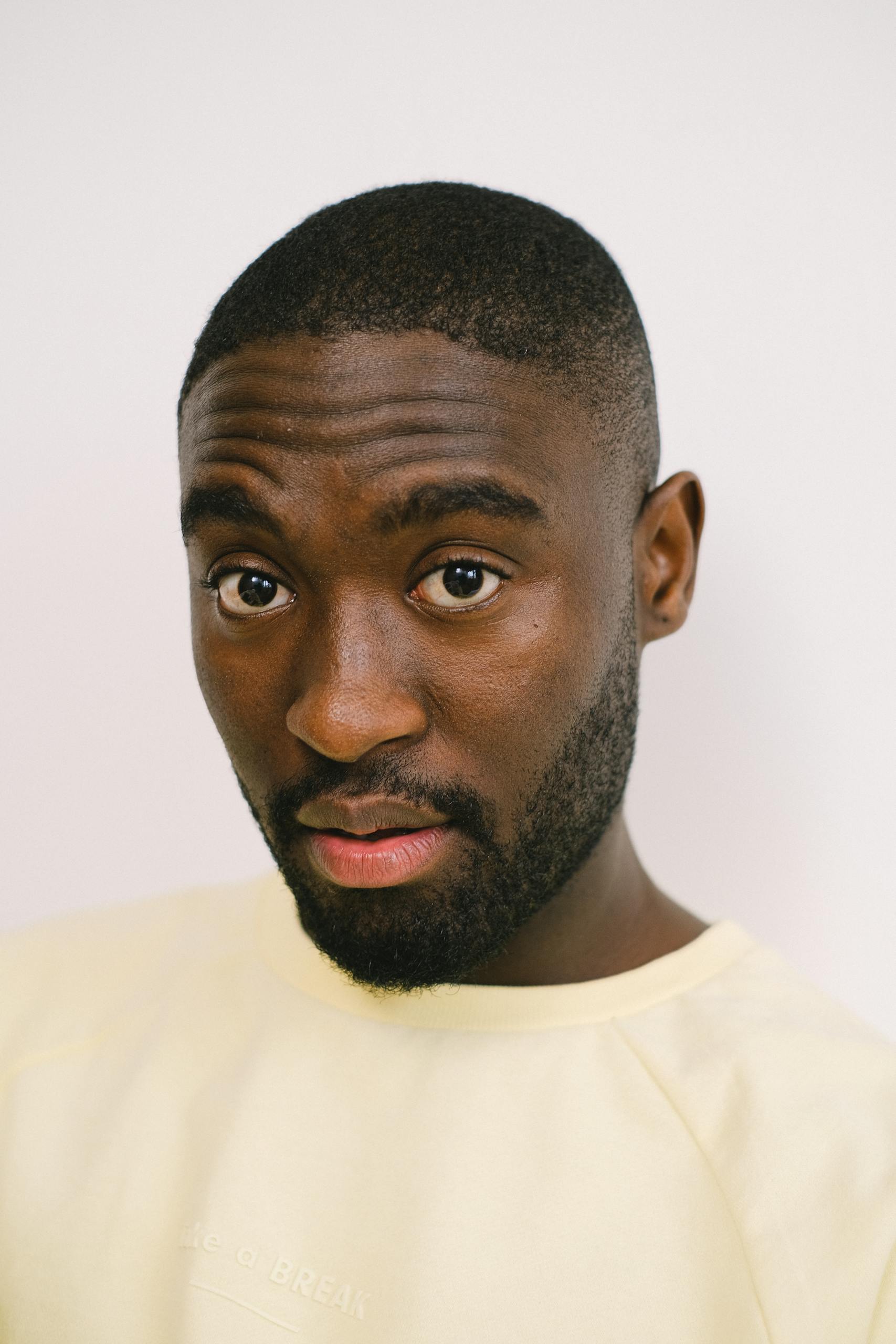 Berniece Julien Close-up portrait of a man with a neutral white background, showcasing expression and style.
