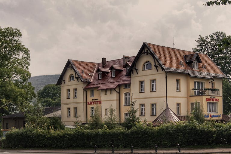 Enntal Elegant hotel in Świeradów-Zdrój, Poland with classic architecture amidst lush greenery.