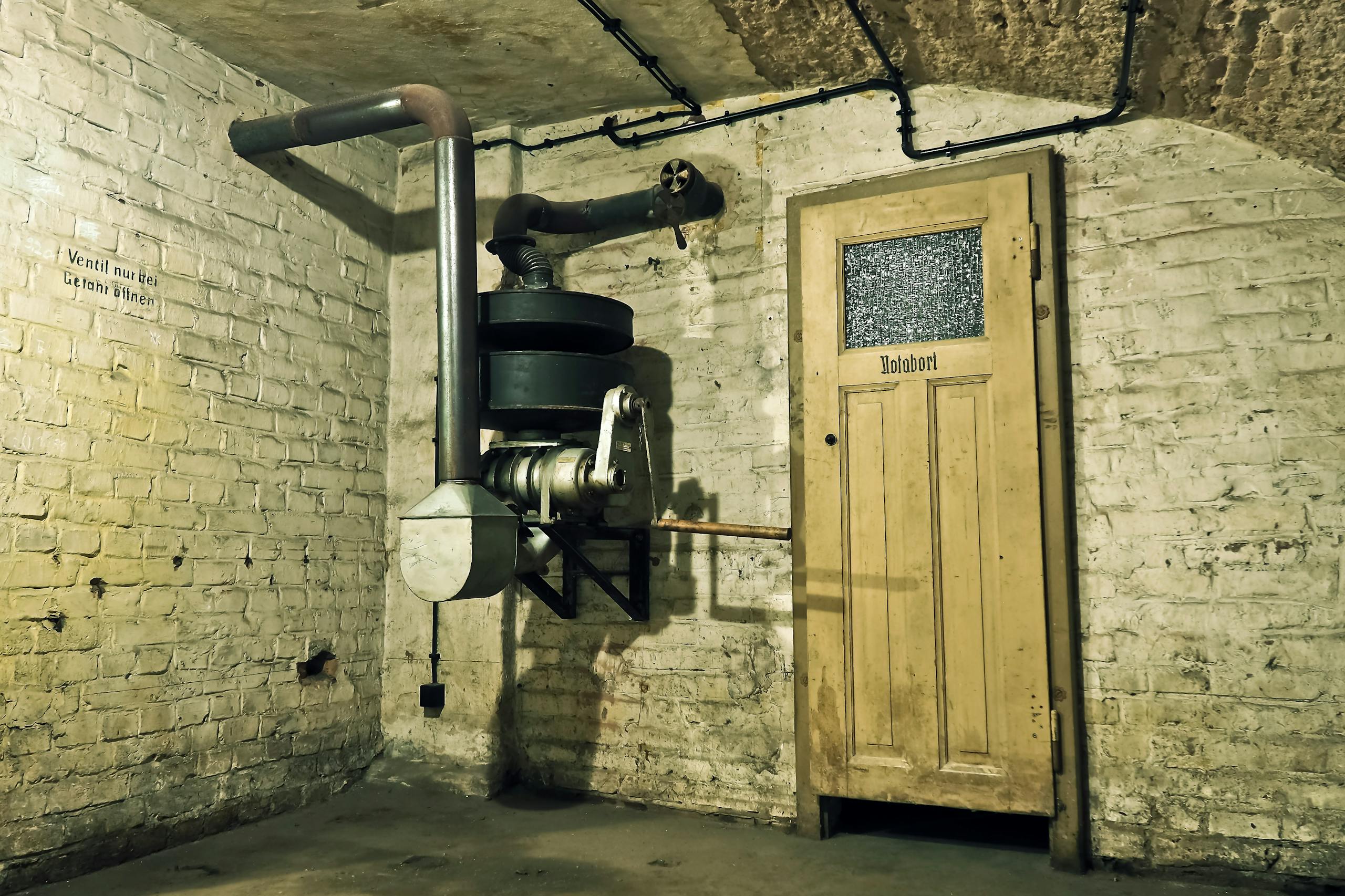 Crackstube Explore an abandoned underground air raid shelter with vintage machinery and a wooden door.