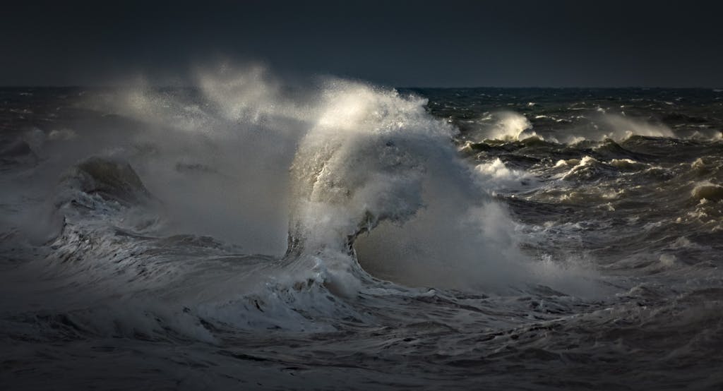Stormuring Powerful ocean waves crash with splashes against a dark sky, capturing nature's raw energy.
