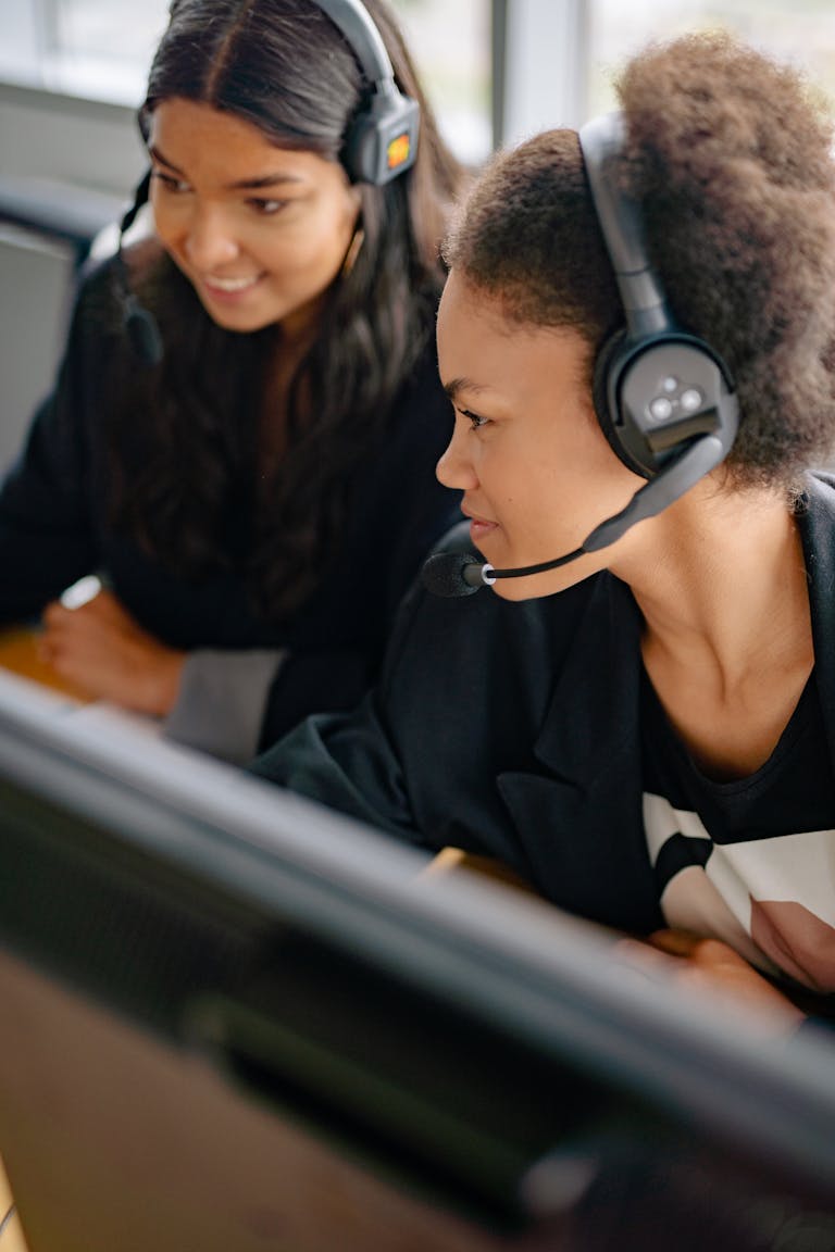 Century LinkT wo diverse women working as call center agents in an office setting.