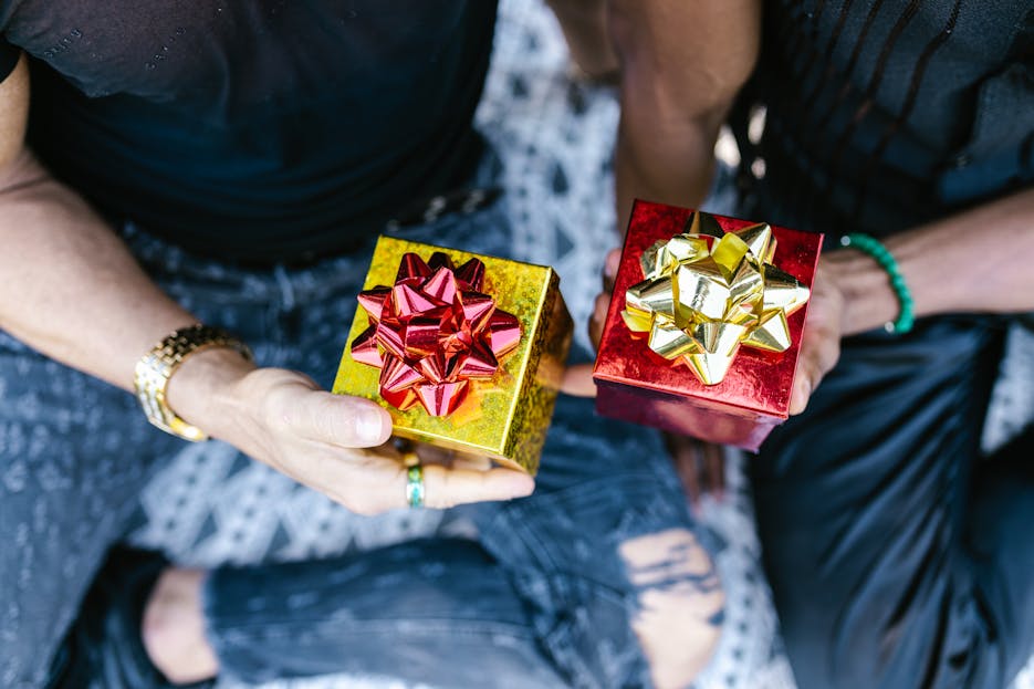 WhatUTalkingBoutWillis Gift Guide Two people holding beautifully wrapped gift boxes with bows, perfect for celebrations.