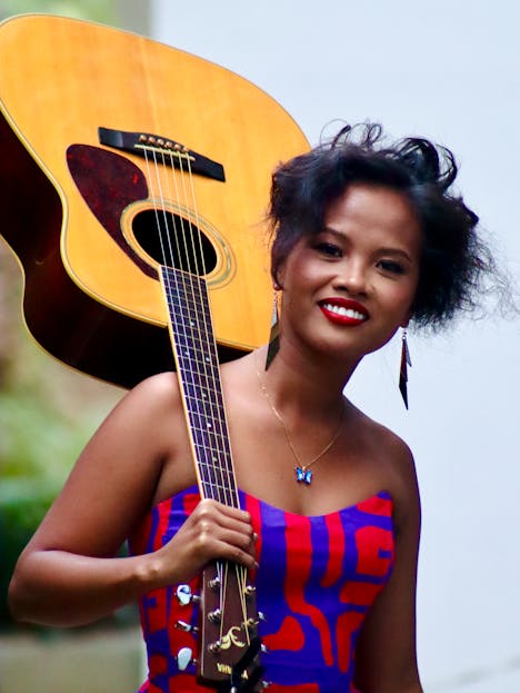 Wendy Etris Young Asian woman with guitar, vibrant style, smiling outdoors in Cebu City.